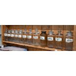Fourteen glass apothecary jars with enamelled and gilt labels to/w a Kutnows Powders bottle