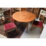 A vintage G-Plan circular extending teak dining table, 112 cm dia. x 73.5 cm h to/with a set of four
