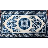 A Chinese blue and white small Peking rug of typical design, 89 x 52 cm to/w a Moroccan red ground