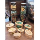 Two painted Russian turned wood bottle holders to/w three graduated sets of embossed and painted