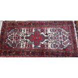 A contemporary rug/runner, the geometric design on red and cream ground, 198 cm x 94 cm