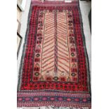 A Persian Baluch tan ground rug, flora and fauna designs and red border with kelim ends, 190 x 94 cm