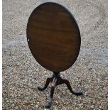 A Georgian style mahogany tilt top table raised on a birdcage tripod base, 83 cm dia. x 74 cm h