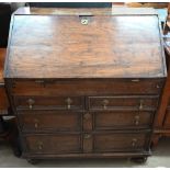 An antique oak fall front bureau with fitted interior and six drawers standing on bun feet 94 cm w x