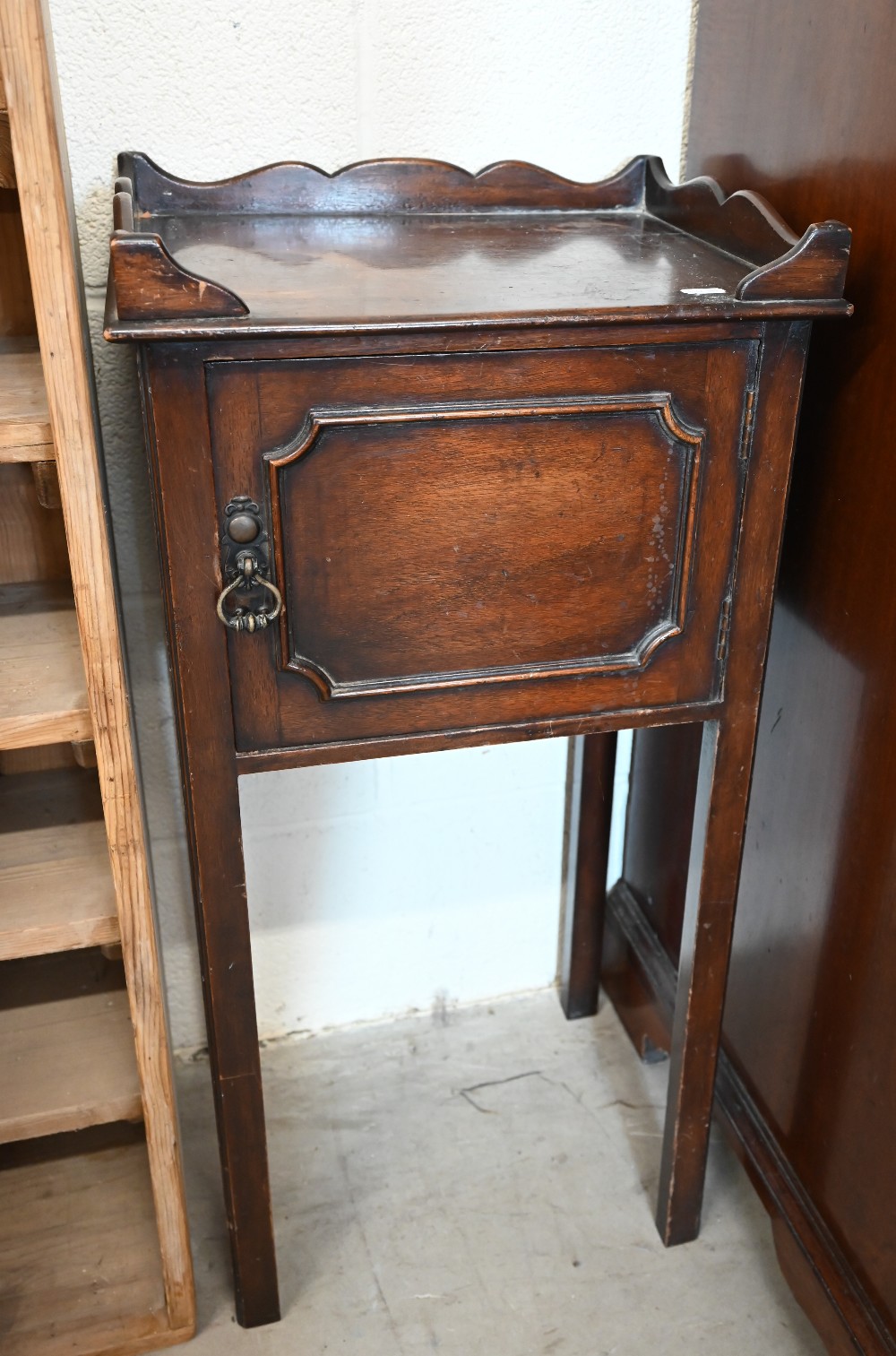 A small mahogany pot cupboard with galleried top, panelled door and slender supports, 38 cm wide x