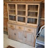 An old pine part glazed dresser, the upper part with three glazed cabinets over three drawers over