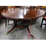 A circular mahogany and box-strung dining table, the top with segmented veneers on base with four