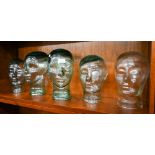 Five various glass heads (hat or wig-stands), 25-27 cm