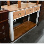 A waxed pine dresser base with three drawers and cupped brass handles in white part-painted frame