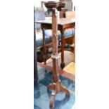 A Gothic oak candlestand with a trio of white metal bobeche, faceted column and triform supports, 68