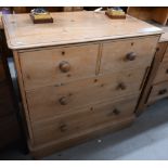 A small antique pine chest of two short over two long drawers with turned handles, raised on