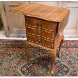 A reproduction walnut drop leaf lamp table with three drawers raised on cabriole supports