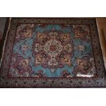 Machine made Persian design carpet with stylised floral design on turquoise ground within