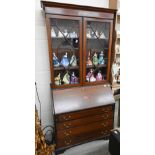 An Edwardian bureau bookcase with astragal glazed doors and fall front panel over four long