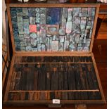 Two trays of printing blocks - one with large letters, the other with emblems, insignia and motifs