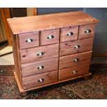 A pine chest of four short over six further drawers, on turned feet (the top paint spattered), 92