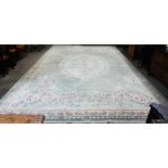 A large Chinese cut-wool carpet, floral design on sage green ground with cream borders, 550 x 357 cm