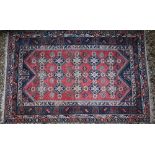 A Turkish kelleigh carpet, geometric design with diamond medallions on red ground with blue