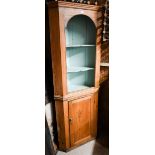 An antique pine two-tier corner cupboard on plinth base