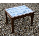 A teak coffee table the top inset with twelve antique Delft blue and white glazed tiles