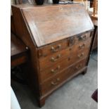 A Georgian oak fall front bureau with six drawers (the small drawer with secret compartment), raised