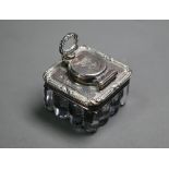 A George IV travelling inkwell with reeded glass body, the silver top with hinged cover secured by a