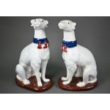 A pair of 20th century glazed terracotta heraldic seated talbots with tasselled collars, on oval