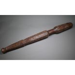An antique hardwood tribal baton, multi-faceted and scratch carved with geometric and circular