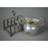 A small silver toast rack, Chester 1925, to/w an Edwardian cream jug, Birmingham 1908 (2) 4.6oz