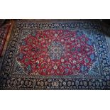 A central Persian Isfahan carpet, centred by a floral medallion on red ground, 380 cm x 285 cm