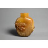A Chinese butterscotch agate snuff bottle, carved in relief with a sage, deer, crane and pine tree -