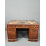 Maple & Co. Ltd. a Victorian mahogany twin pedestal desk, the battered leather top over nine