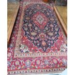 A contemporary central Persian Kashan carpet, the blue and red ground centred by a floral medallion,