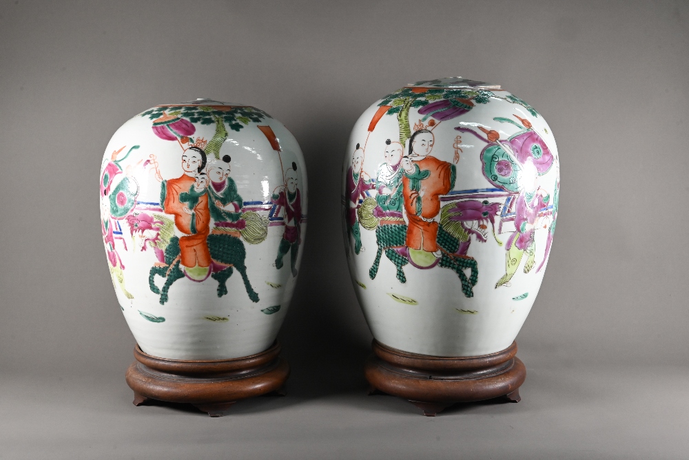 A pair of 19th century Chinese famille rose ovoid vases with covers (missing finials) painted in