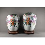 A pair of 19th century Chinese famille rose ovoid vases with covers (missing finials) painted in