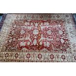 A contemporary Indian Agra carpet, the red-pink ground with stylised floral design, 323 cm x 242
