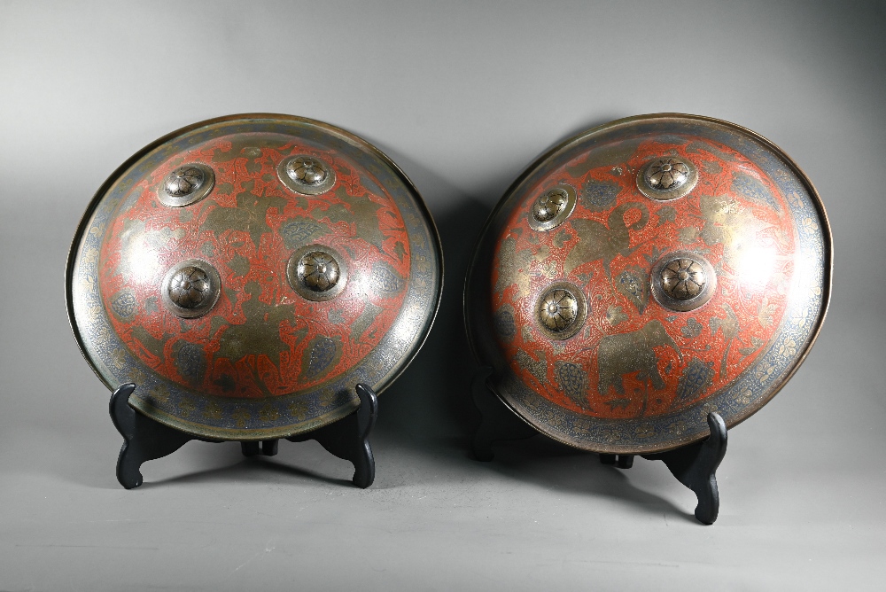 A pair of Indian Benares brass circular shields, dhal, each with four raised bosses chased