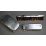 Two Art Deco engine-turned silver-backed brushes, Birmingham 1936, to/w a silver-mounted comb