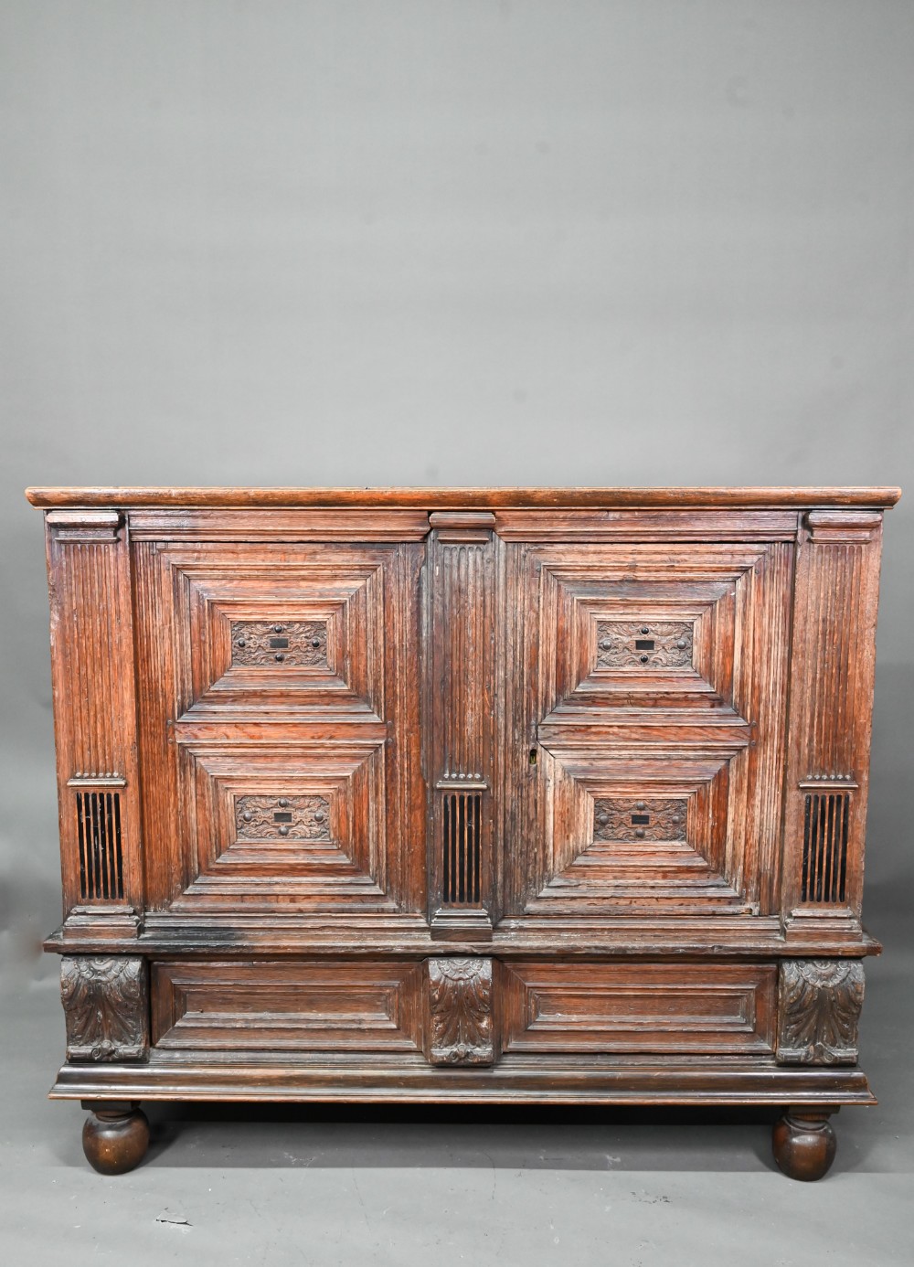 A 17th century jointed oak cupboard, with two moulded panelled doors over a full width drawer,