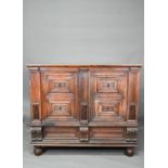 A 17th century jointed oak cupboard, with two moulded panelled doors over a full width drawer,