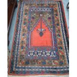 A contemporary Turkish prayer design rug, the coral ground centre panel flanked by stylised floral