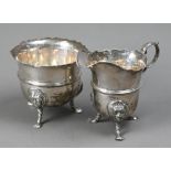 An Edwardian silver cream & sugar pair, with cut rims, scroll handles and lion-mask monopodia,