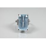 A rectangular aquamarine and diamond ring, the baguette cut aquamarine with three claw set