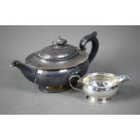 An ovoid silver bachelor teapot with beaded rim, composite handle and finial, on spread foot rim,