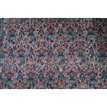 An antique Persian Qom rug, repeating floral vase design on camel ground, 220 cm x 138 cm