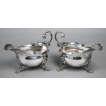 Pair of George III silver pot-bellied sauce-boats with scroll handles and shell feet, Fuller