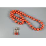 An antique coral necklace of irregular cylindrical beads, double knotted throughout, 25 cm long (