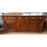 An 18th century oak and elm low dresser base with three drawers over three fielded panel doors, with