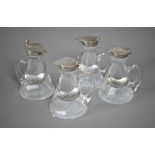 A matched set of four conical glass whisky noggins with star-cut bases and silver collars and