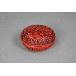 A 20th century Chinese cinnabar style circular box and cover, moulded with a floral and foliate